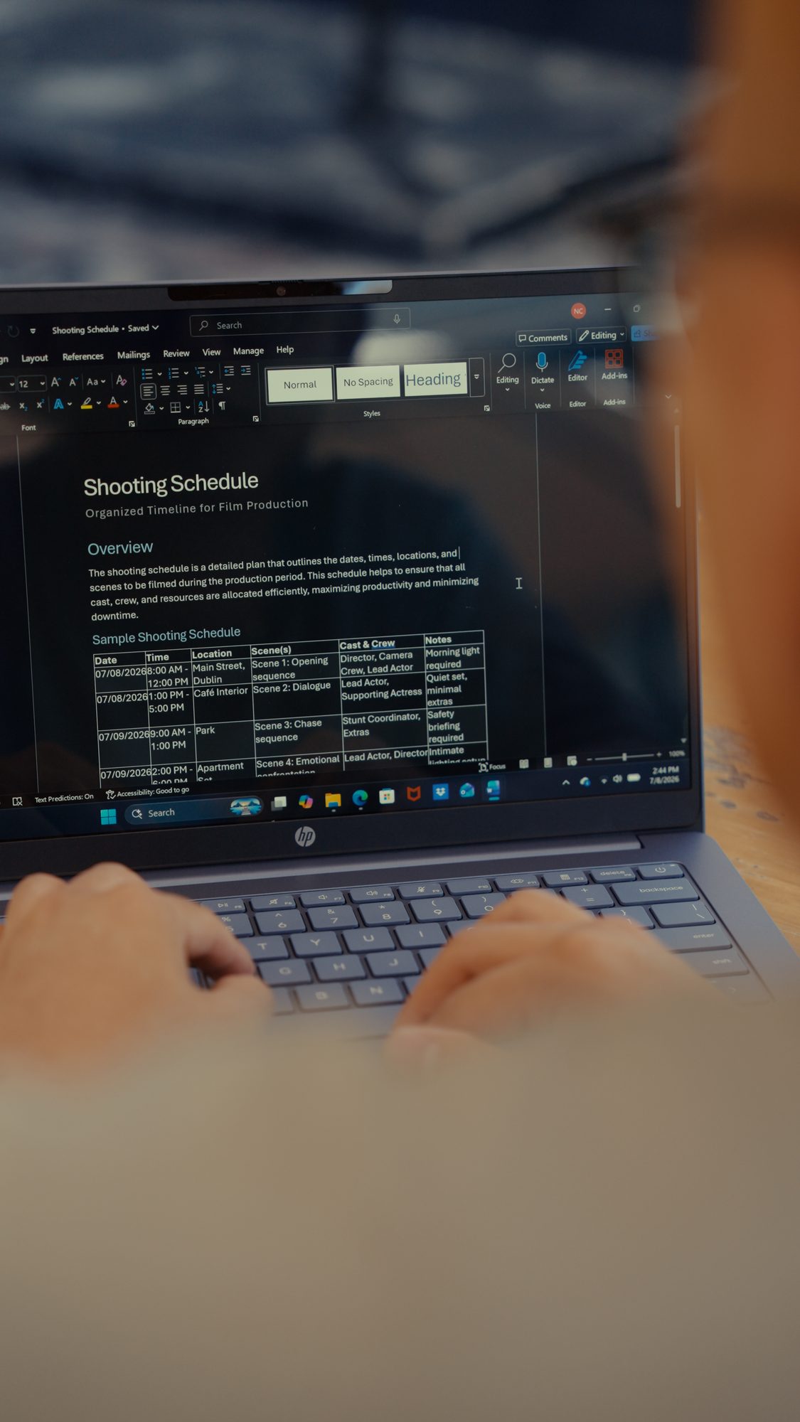 Drafting a shooting schedule in Microsoft Word on a laptop