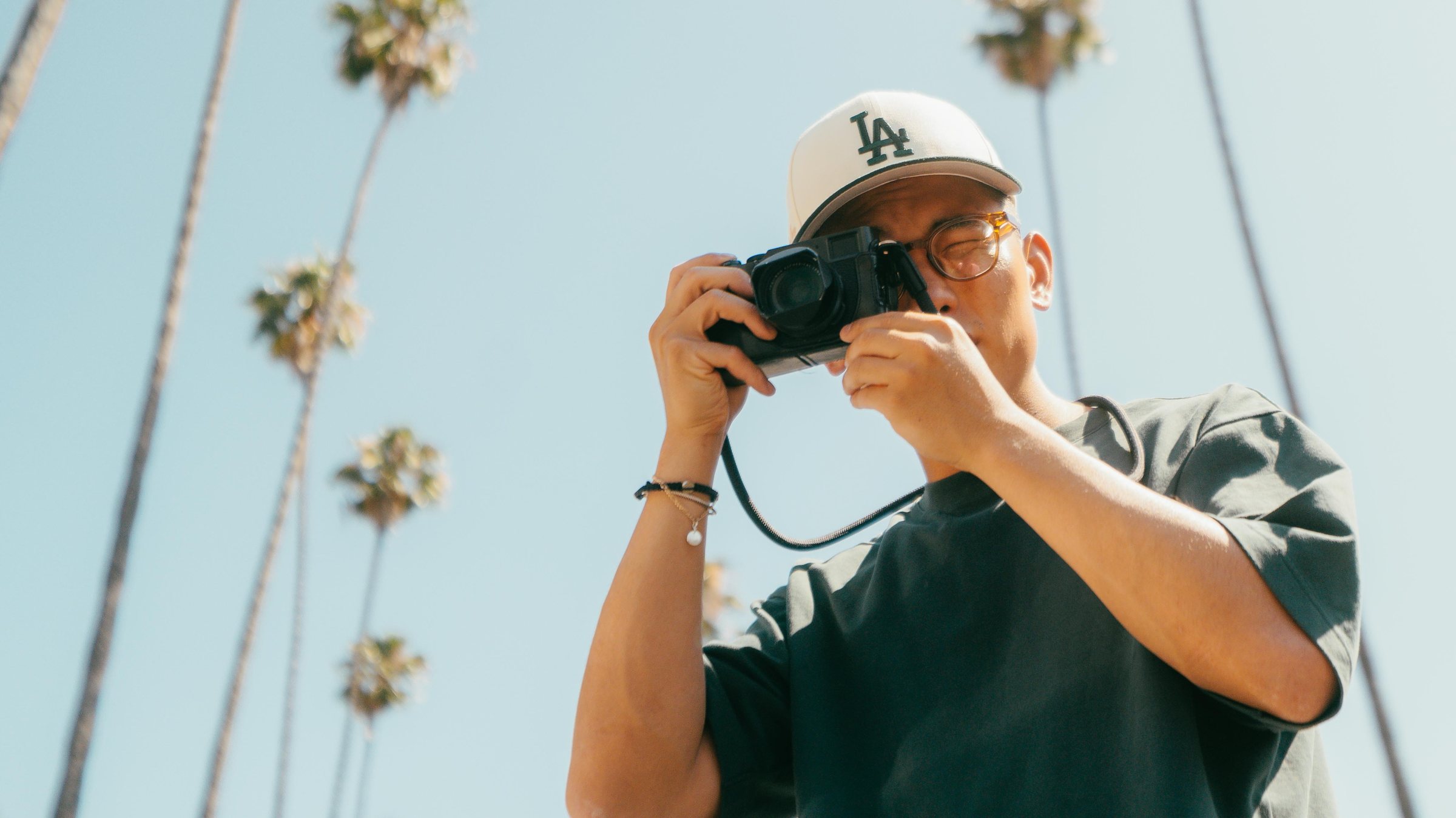 Nicolas Chae framing a shot under Los Angeles palms